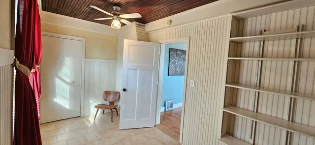 a view of an empty room with wooden floor and a cabinet