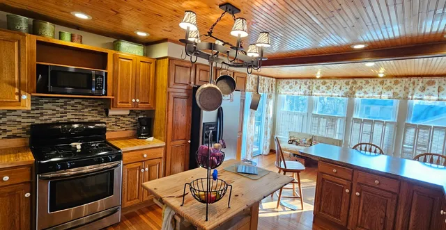a kitchen with stainless steel appliances granite countertop a stove top oven a sink and cabinets
