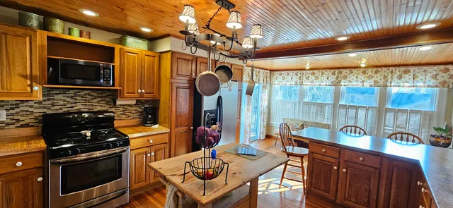 a kitchen with stainless steel appliances granite countertop a stove a sink and a microwave