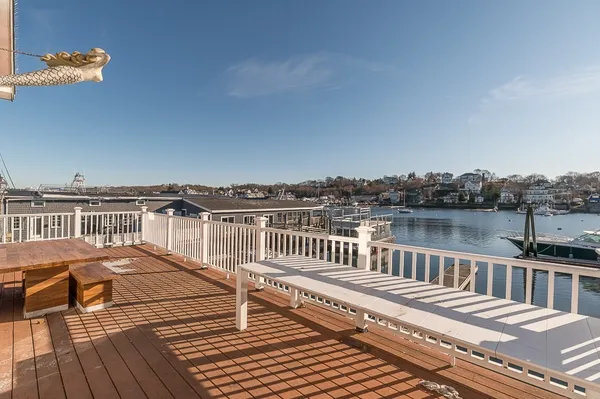 an aerial view of ocean and residential houses with outdoor space