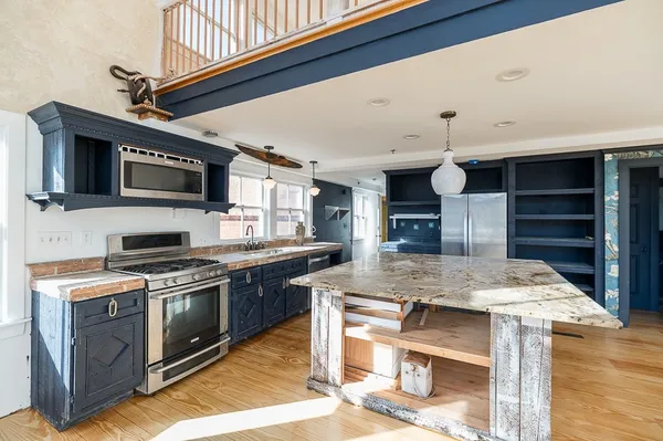 a kitchen with stainless steel appliances granite countertop a stove and a microwave