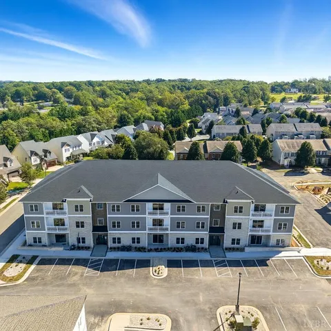 an aerial view of residential houses with outdoor space and parking