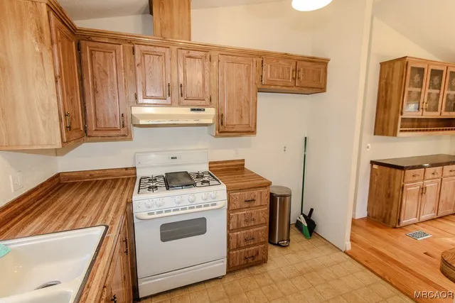 a white stove top oven sitting inside of a kitchen