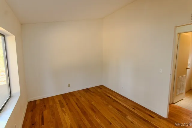 a view of a room with wooden floor and bench