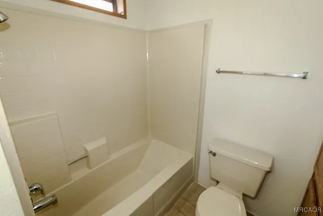a white toilet sitting next to a bath tub