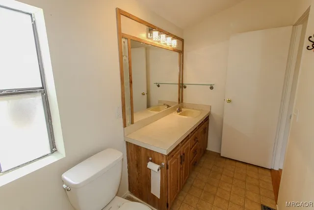 a bathroom with a sink a toilet and a mirror