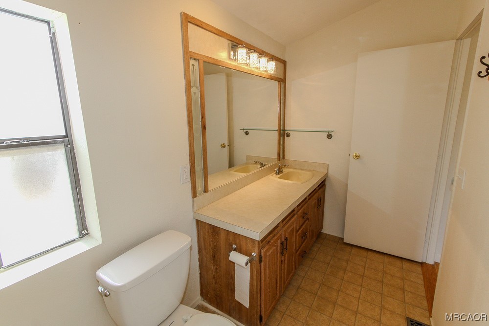 1197 Mitchell Lane Big Bear City, CA 92386 - Photo 25 of 32 a bathroom with a sink a toilet and a mirror