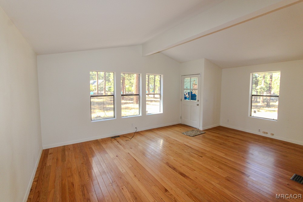 1197 Mitchell Lane Big Bear City, CA 92386 - Photo 6 of 32 a view of an empty room with wooden floor and a window