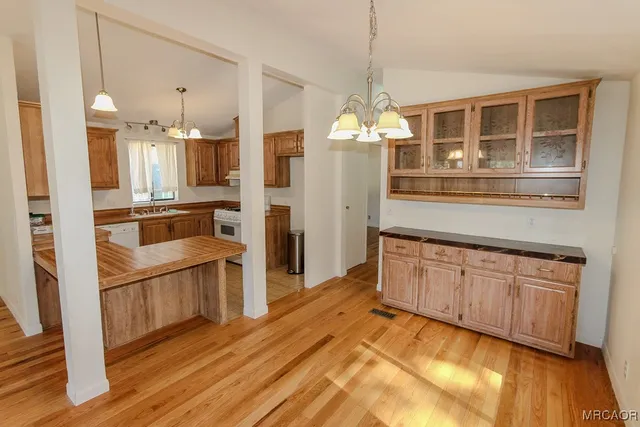 a kitchen with granite countertop stainless steel appliances and wooden floor