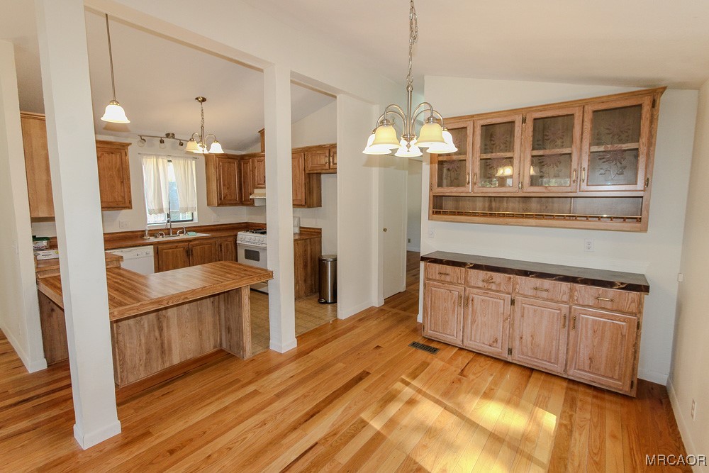1197 Mitchell Lane Big Bear City, CA 92386 - Photo 9 of 32 a kitchen with granite countertop stainless steel appliances and wooden floor