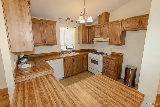 a view of a kitchen with wooden floor and electronic appliances