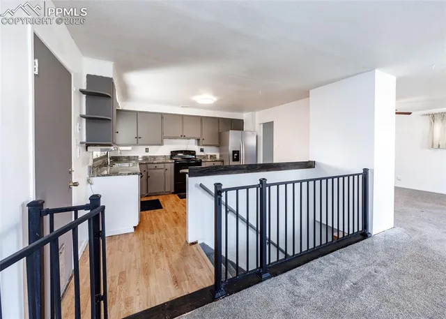 a kitchen with stainless steel appliances granite countertop a refrigerator a stove top oven and white cabinets