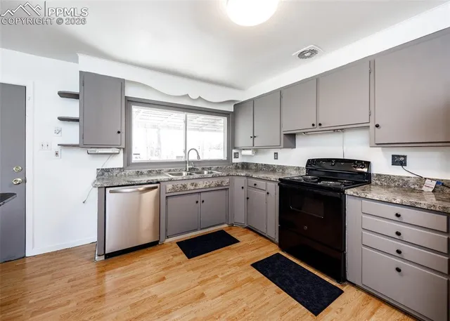 a kitchen with granite countertop cabinets stainless steel appliances and a window