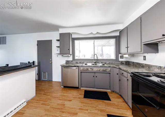 a kitchen with granite countertop stainless steel appliances a sink cabinets and a window