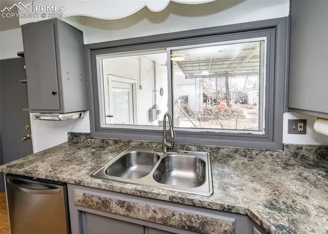 a kitchen with granite countertop a sink and a stove