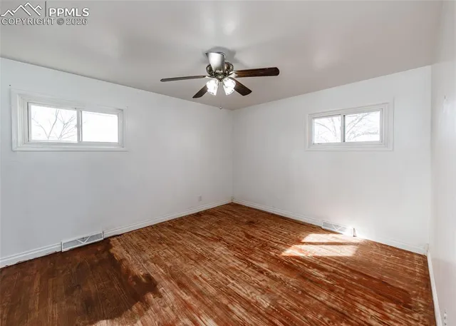 a view of empty room with wooden floor