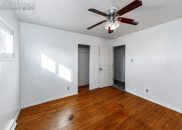 an empty room with fan and windows