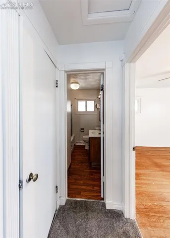 a view of a hallway with toilet and a livingroom