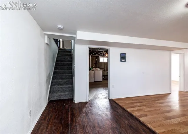 a view of a hallway with wooden floor and stairs