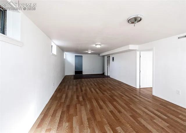 a view of empty room with wooden floor