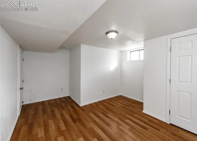 a view of empty room with wooden floor