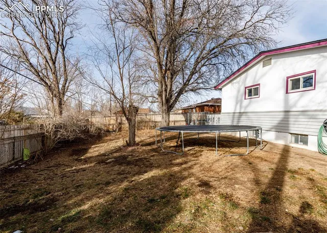 a view of a house with a yard and trees