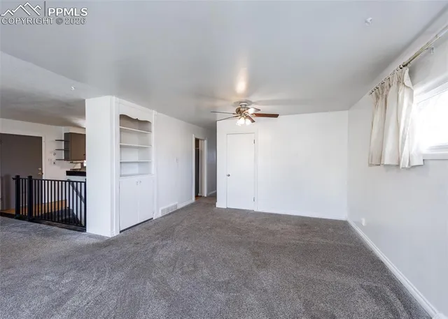 an empty room with closet and windows
