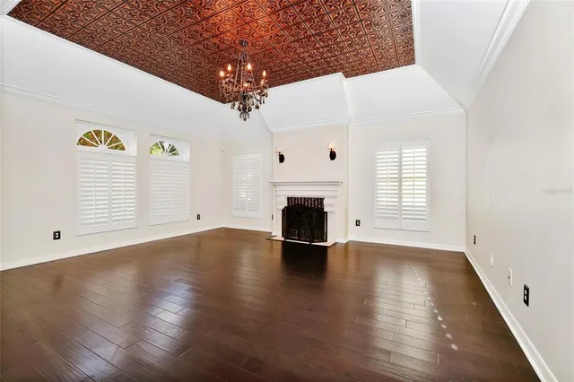 an empty room with windows and fireplace