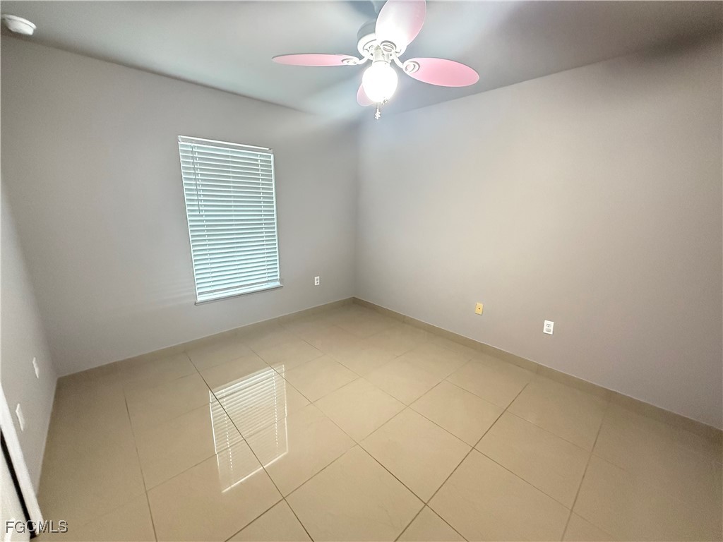 3207 54th Street West Lehigh Acres, FL 33971 - Photo 9 of 13 an empty room with a ceiling fan and window