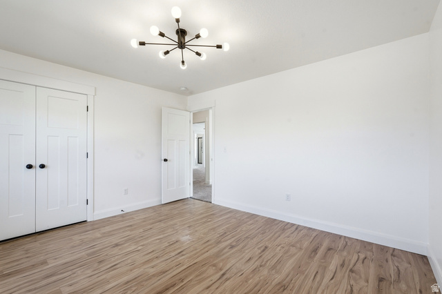 338 Windy Rdg Drive Smithfield, UT 84335 - Photo 24 of 63 Room featuring wood-finish flooring, white walls, and a modern sputnik chandelier