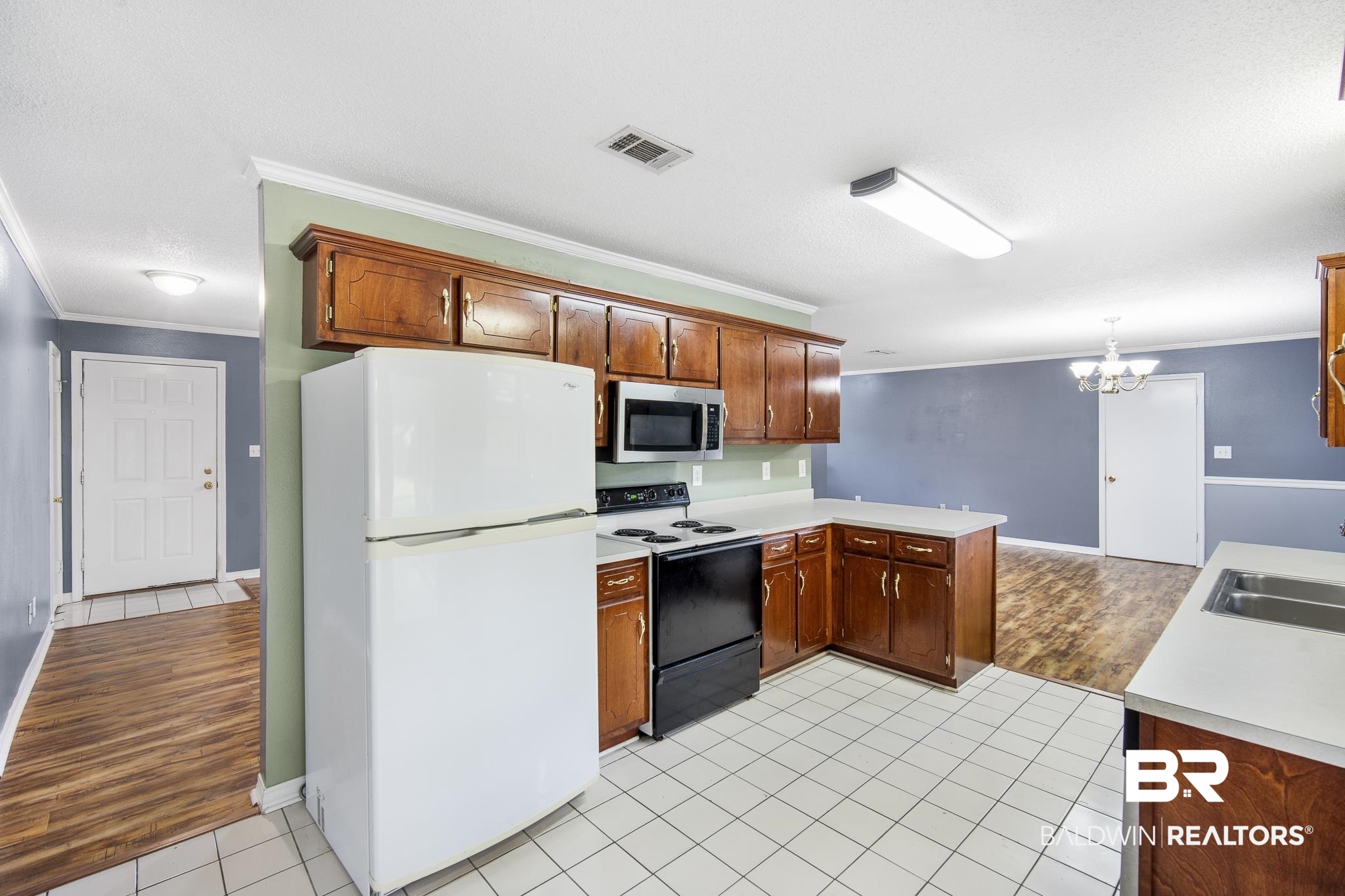 103 Ann Street Daphne, AL 36527 - Photo 7 of 23 Kitchen with freestanding refrigerator, light countertops, electric range, light tile patterned floors, and ornamental molding