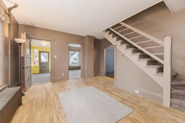 a view of a room that has a bed and wooden floor
