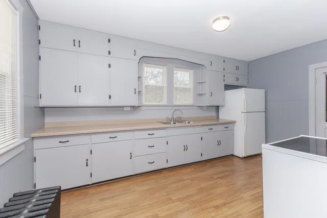a kitchen with granite countertop white cabinets and white appliances