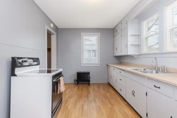 a kitchen with a sink a stove and cabinets