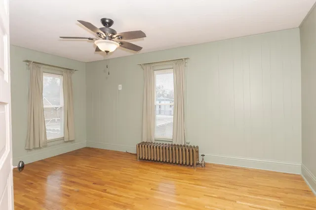 a view of a room with wooden floor and fan