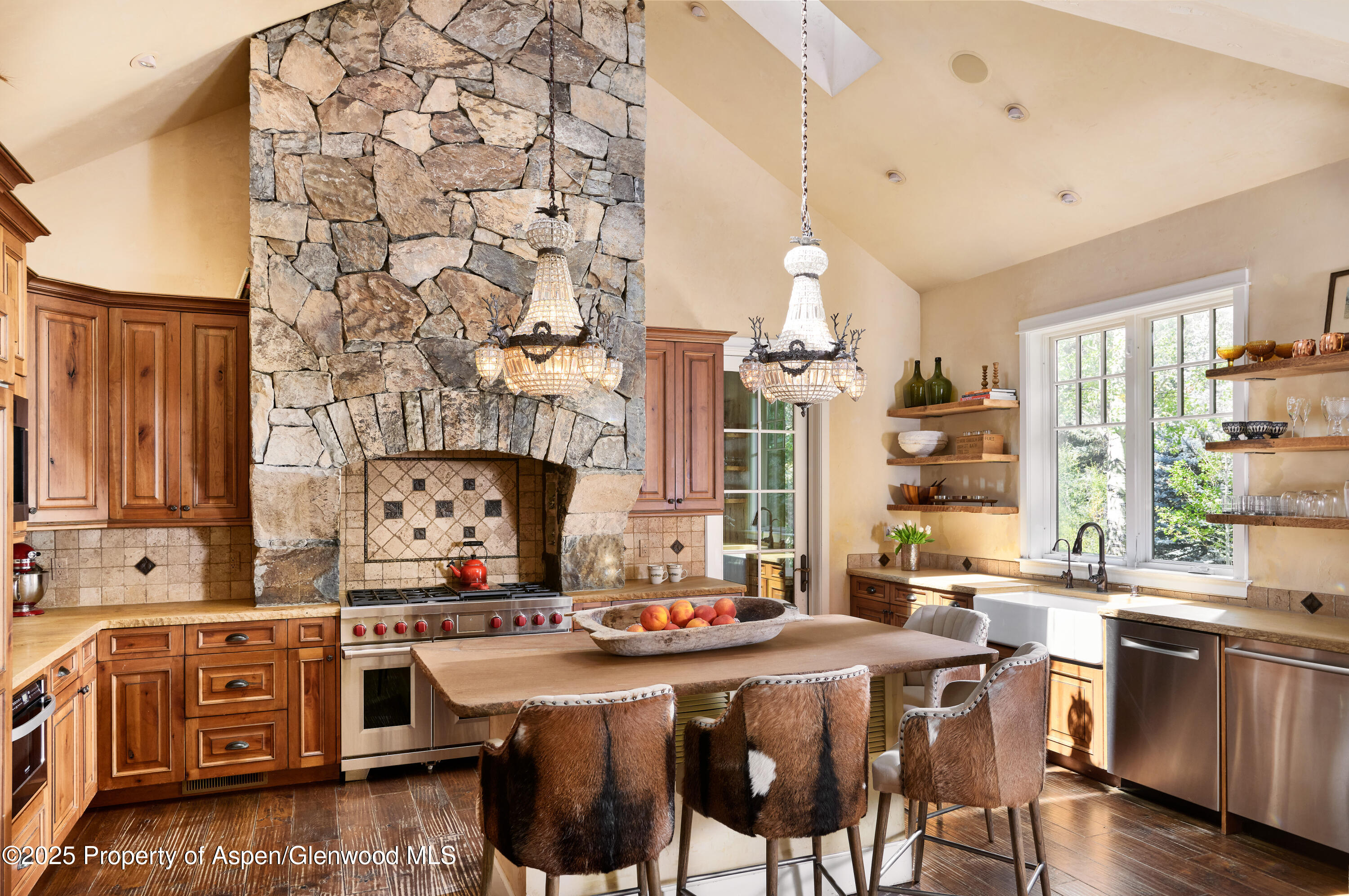1900-1902 Snowmass Creek Road Snowmass, CO 81654 - Photo 8 of 74 a kitchen with stainless steel appliances a stove a sink dishwasher and a dining table with wooden cabinet