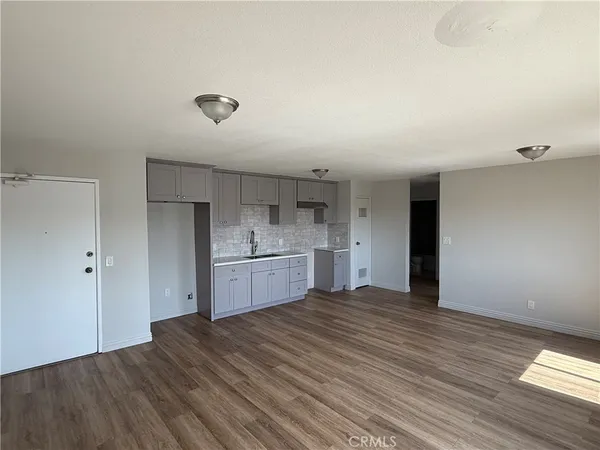 a view of a kitchen with wooden floor and a sink