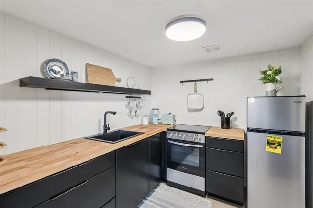 a kitchen with stainless steel appliances granite countertop a sink a stove and cabinets