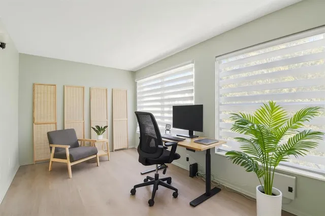 a view of a workspace with furniture and a window