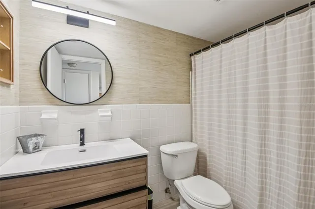 a bathroom with a sink a toilet and a mirror