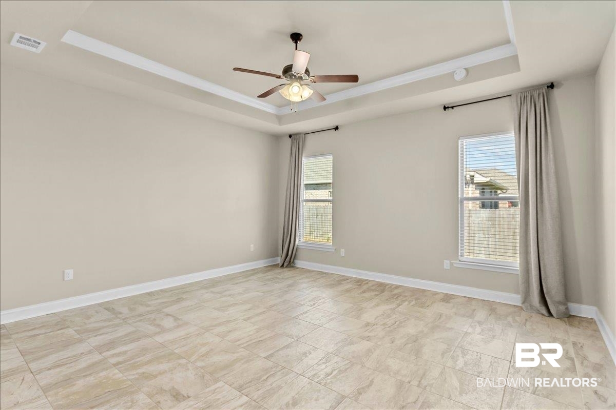 1112 Stella Road Foley, AL 36535 - Photo 13 of 33 Unfurnished room featuring a tray ceiling, healthy amount of natural light, and ceiling fan
