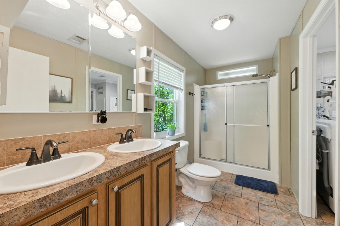 44586 Maplewood Court Callahan, FL 32011 - Photo 7 of 19 a bathroom with a granite countertop double vanity sink a mirror and a toilet
