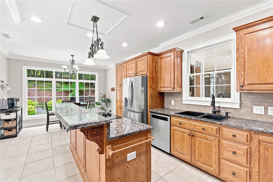 320 Watson Road Easley, SC 29642 - Photo 13 of 50 Rich wood cabinetry and stone countertops anchor this classic kitchen design.
