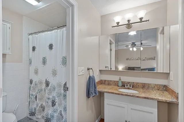a bathroom with a granite countertop sink a shower and a mirror