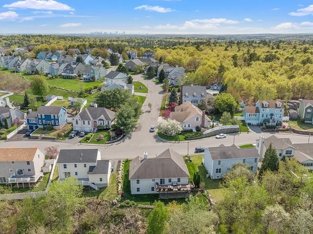 an aerial view of residential houses with outdoor space and ocean view