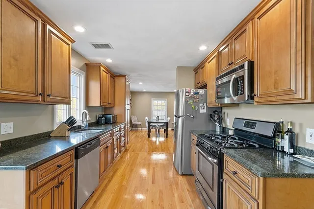 a kitchen with stainless steel appliances granite countertop a stove a sink and a microwave