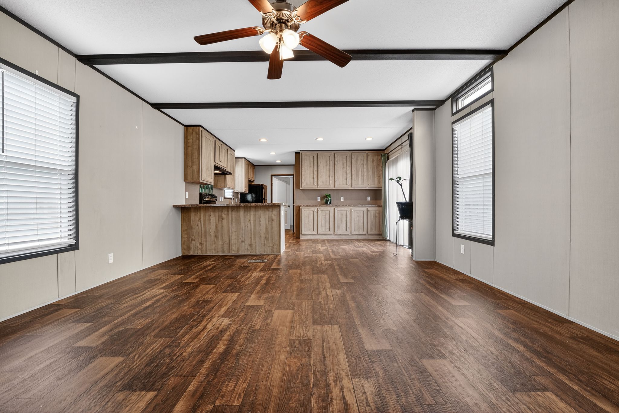 16 4th Street Maxwell, TX 78656 - Photo 19 of 35 a view of a kitchen with a fridge wooden floor and a ceiling fan