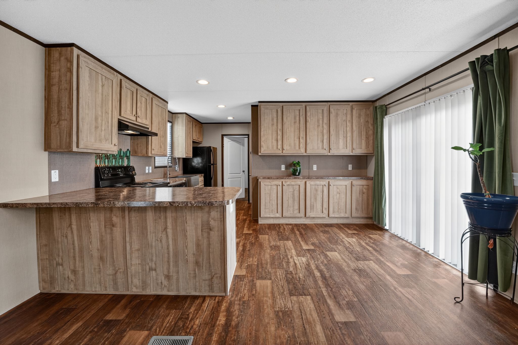 16 4th Street Maxwell, TX 78656 - Photo 23 of 35 a kitchen with granite countertop wooden floors a refrigerator and a sink