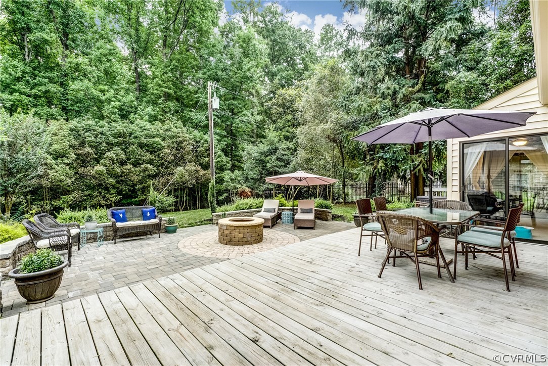 3901 Cheyenne Road Richmond, VA 23235 - Photo 41 of 49 a view of a roof deck with table and chairs under an umbrella with wooden floor