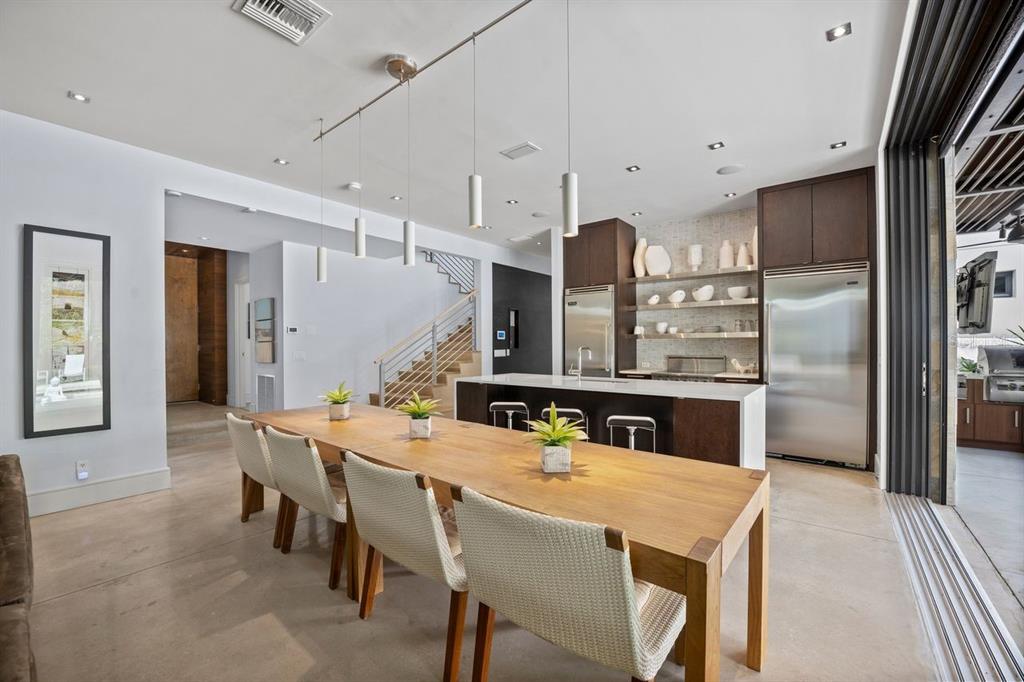 1411 Nottingham Street Orlando, FL 32803 - Photo 9 of 47 a kitchen with stainless steel appliances kitchen island granite countertop a dining table chairs and refrigerator